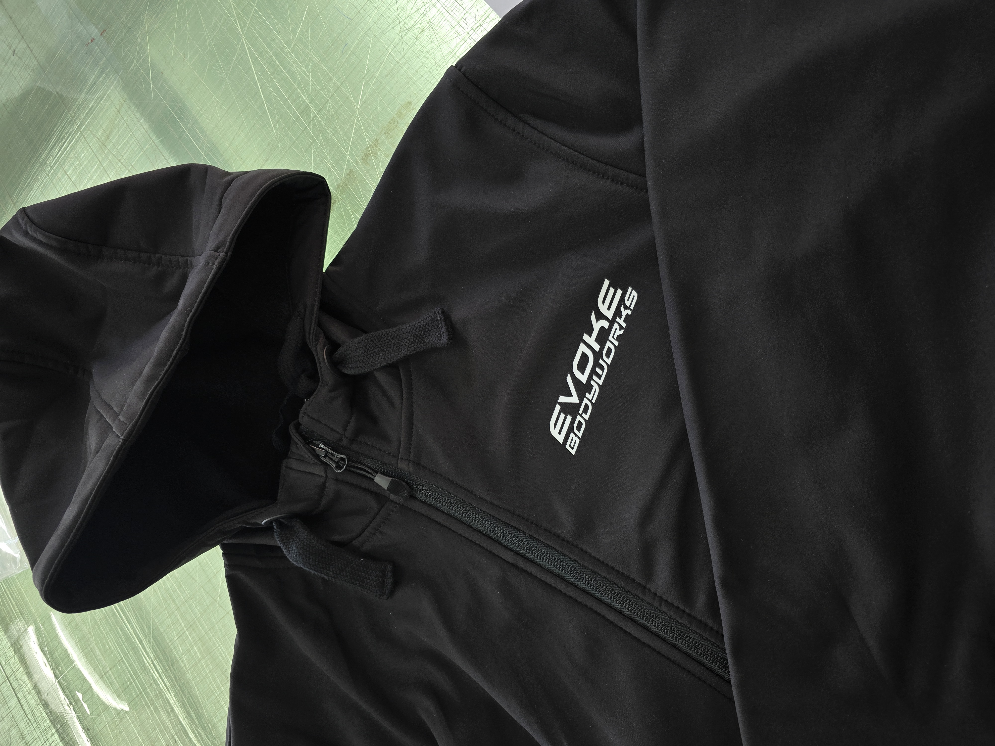 Black Evoke Bodyworks hoodie with vivid printed logo on dark fabric